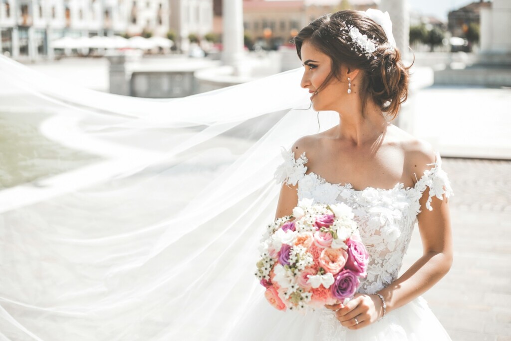 woman in white wedding dress holding bouquet of flowers