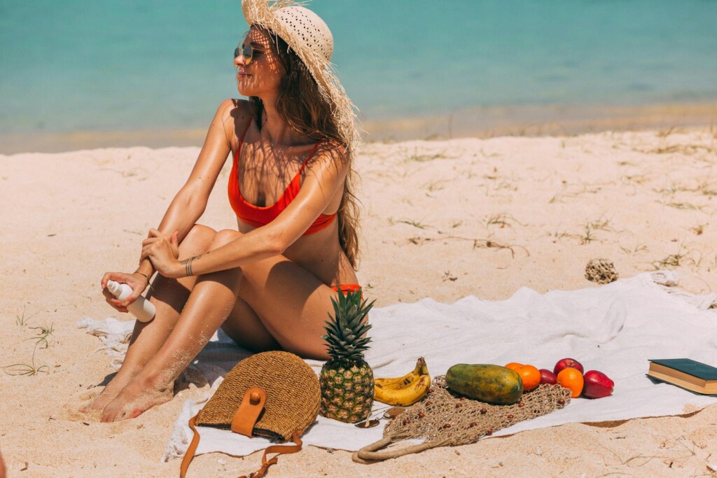 A Woman Sitting on the Beach over a Towel